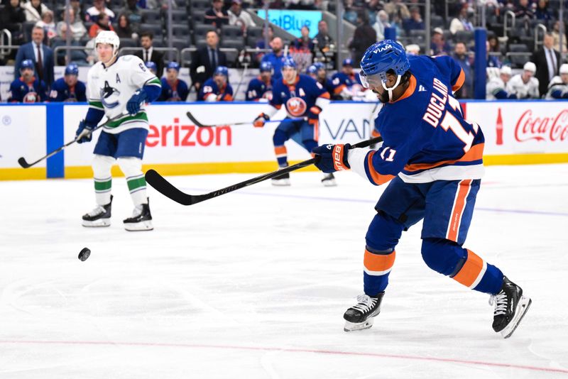 Dec 19, 2025; Elmont, New York, USA; New York Islanders left wing Anthony Duclair (11) shoots the puck against the Vancouver Canucks during the second period at UBS Arena. Mandatory Credit: John Jones-Imagn Images