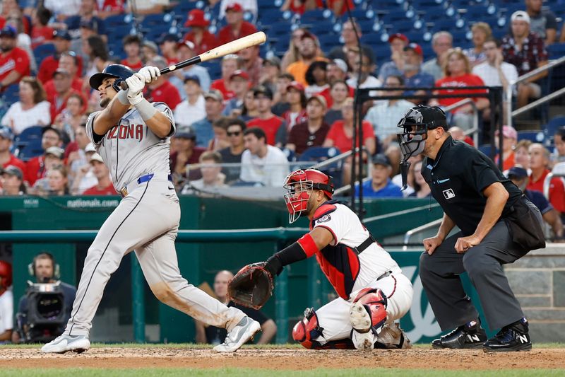 Jun 18, 2024; Washington, District of Columbia, USA; Arizona Diamondbacks catcher Gabriel Moreno (14) hits a sacrifice fly RBI against the Washington Nationals during the sixth inning at Nationals Park. Mandatory Credit: Geoff Burke-USA TODAY Sports