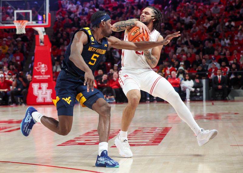 Jan 15, 2025; Houston, Texas, USA;  Houston Cougars guard Emanuel Sharp (21) dribbles against West Virginia Mountaineers guard Toby Okani (5) in the first half at Fertitta Center. Mandatory Credit: Thomas Shea-Imagn Images