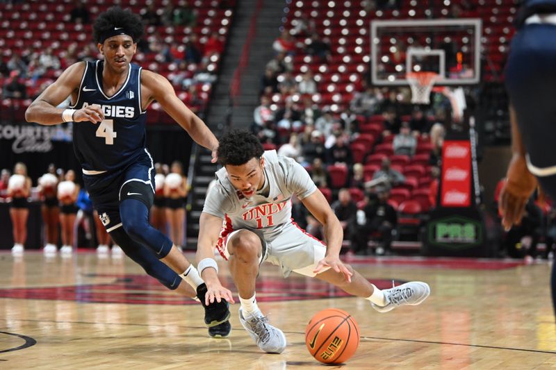 Jan 13, 2024; Las Vegas, Nevada, USA; UNLV Rebels guard Dedan Thomas Jr. (11) falls near Utah State Aggies guard Ian Martinez (4) during the first half at Thomas & Mack Center. Mandatory Credit: Candice Ward-USA TODAY Sports