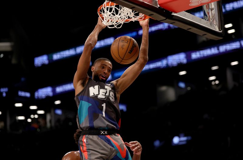 NEW YORK, NEW YORK - NOVEMBER 19:  Mikal Bridges #1 of the Brooklyn Nets dunks over Joel Embiid #21 of the Philadelphia 76ers in the first half at Barclays Center on November 19, 2023 in the Brooklyn borough of New York City. NOTE TO USER: User expressly acknowledges and agrees that, by downloading and or using this photograph, User is consenting to the terms and conditions of the Getty Images License Agreement. (Photo by Elsa/Getty Images)