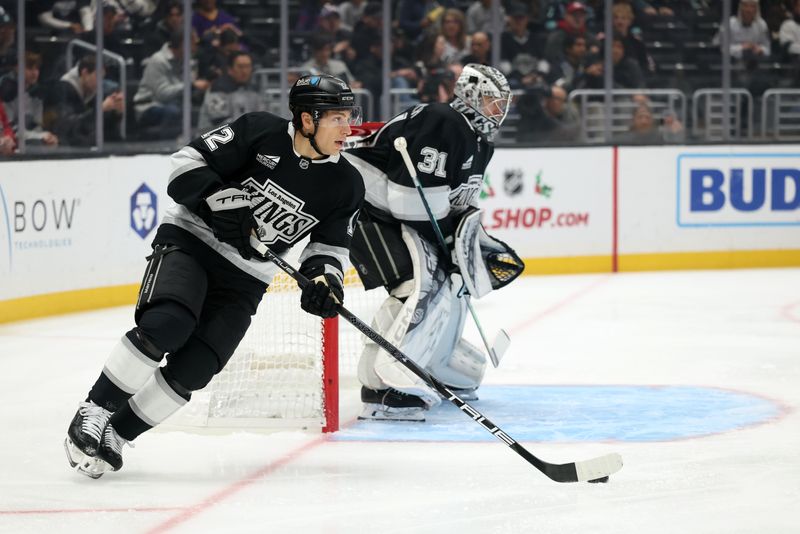 Nov 23, 2024; Los Angeles, California, USA;  Los Angeles Kings left wing Trevor Moore (12) skates with the puck during the first period against the Seattle Kraken at Crypto.com Arena. Mandatory Credit: Kiyoshi Mio-Imagn Images