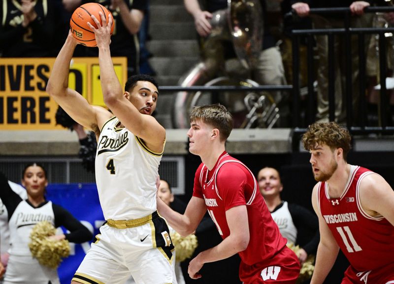 Feb 15, 2025; West Lafayette, Indiana, USA; Purdue Boilermakers forward Trey Kaufman-Renn (4) keeps the ball away from Wisconsin Badgers forward Nolan Winter (31) during the first half at Mackey Arena. Mandatory Credit: Marc Lebryk-Imagn Images