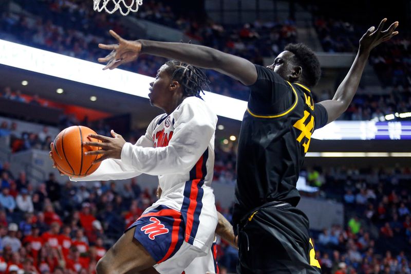 Feb 17, 2024; Oxford, Mississippi, USA; Mississippi Rebels guard Jaylen Murray (5) drives to the basket as Missouri Tigers center Mabor Majak (45) defends during the second half at The Sandy and John Black Pavilion at Ole Miss. Mandatory Credit: Petre Thomas-USA TODAY Sports