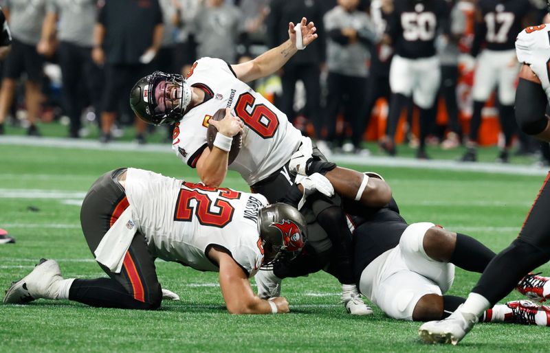 Tampa Bay Buccaneers quarterback Baker Mayfield (6) is sacked by Atlanta Falcons defensive tackle David Onyemata (90) during the second half of an NFL football game Thursday, Oct. 3, 2024, in Atlanta. (AP Photo/Butch Dill)