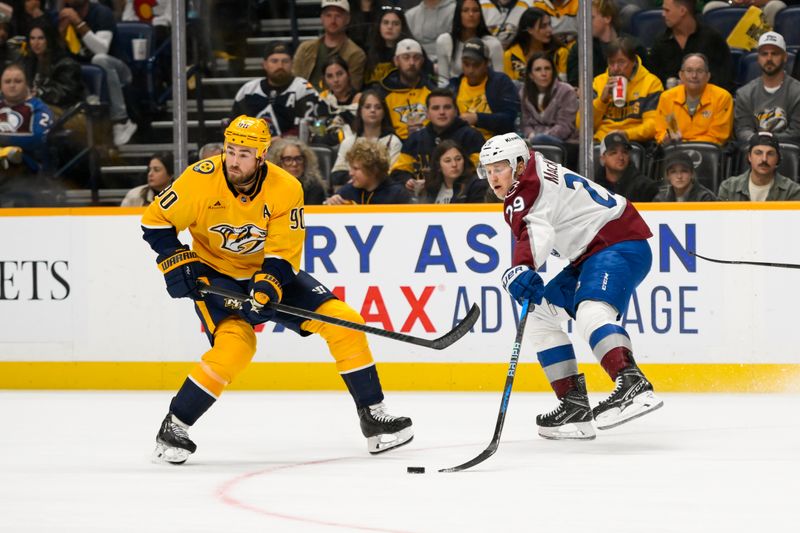 Nov 2, 2024; Nashville, Tennessee, USA;  Nashville Predators center Ryan O'Reilly (90) and Colorado Avalanche center Nathan MacKinnon (29) fight for the puck during the second period at Bridgestone Arena. Mandatory Credit: Steve Roberts-Imagn Images