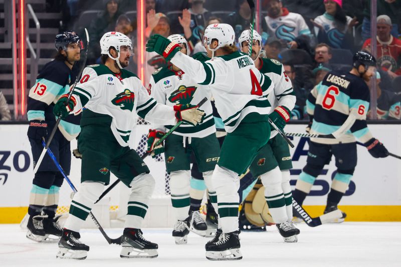 Feb 24, 2024; Seattle, Washington, USA; Minnesota Wild left wing Marcus Johansson (90) celebrates with defenseman Jon Merrill (4) after scoring a goal against the Seattle Kraken during the first period at Climate Pledge Arena. Mandatory Credit: Joe Nicholson-USA TODAY Sports