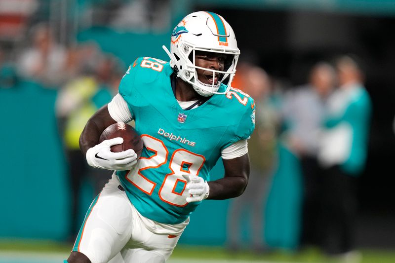 Miami Dolphins running back De'Von Achane (28) runs with the football during the first half of an NFL football game against the Tennessee Titans, Monday, Dec. 11, 2023, in Miami, Fla. (AP Photo/Lynne Sladky)