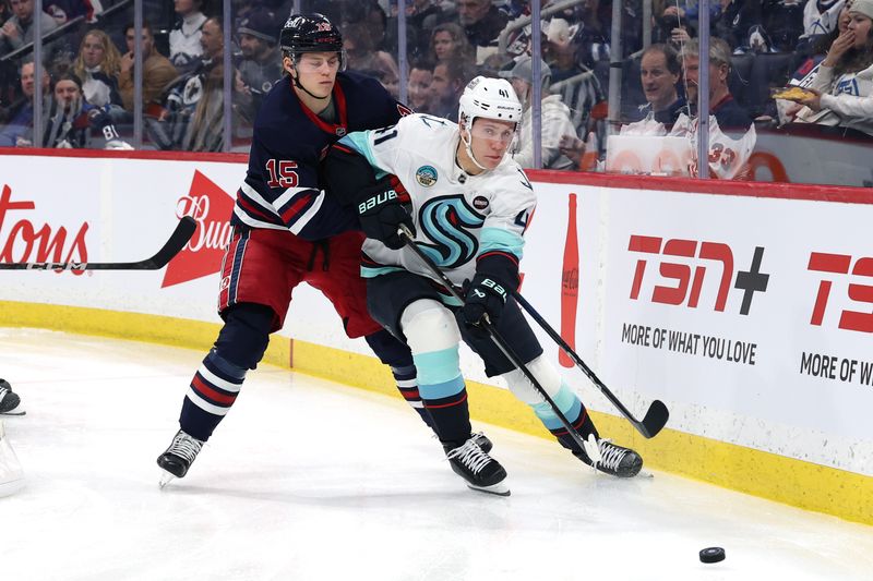 Jan 16, 2025; Winnipeg, Manitoba, CAN; Seattle Kraken defenseman Ryker Evans (41) is checked by Winnipeg Jets center Rasmus Kupari (15) in the second period at Canada Life Centre. Mandatory Credit: James Carey Lauder-Imagn Images