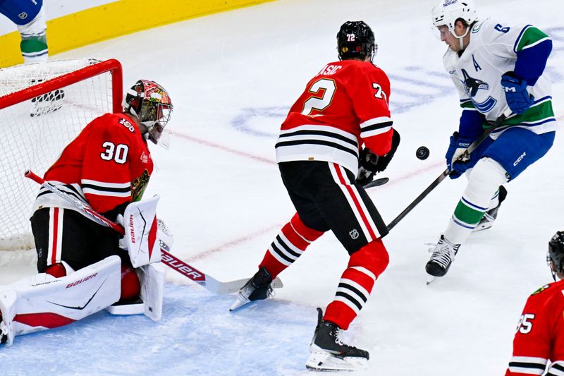Oct 17, 2025; Chicago, Illinois, USA;  Chicago Blackhawks defenseman Alex Vlasic (72) and  goaltender Spencer Knight (30) defend against Vancouver Canucks right wing Brock Boeser (6) during the second period at the United Center. Mandatory Credit: Matt Marton-Imagn Images