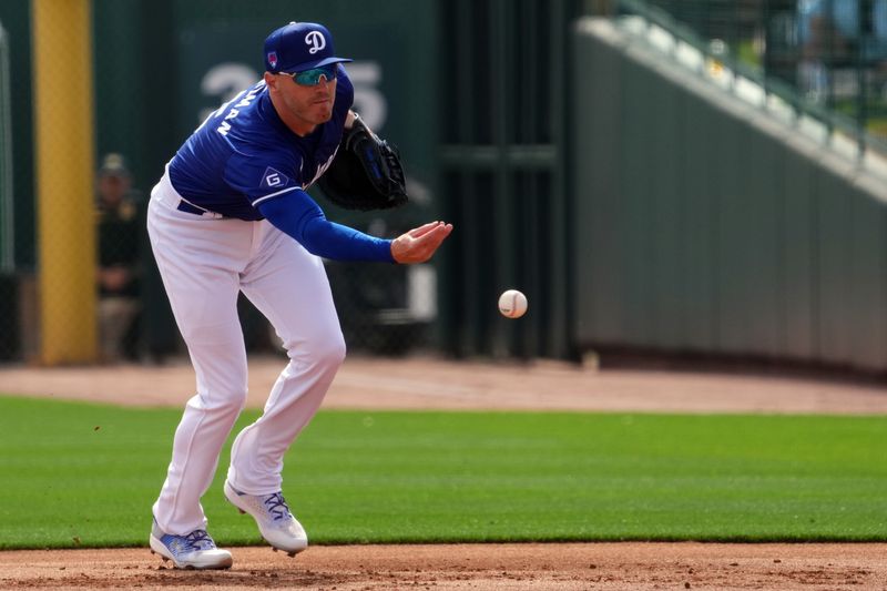 Feb 27, 2024; Phoenix, Arizona, USA; Los Angeles Dodgers first baseman Freddie Freeman (5) flips the ball to first base against the Chicago White Sox during the first inning at Camelback Ranch-Glendale. Mandatory Credit: Joe Camporeale-USA TODAY Sports