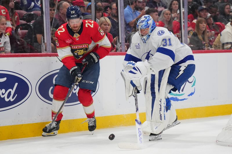 Sep 30, 2024; Sunrise, Florida, USA; Tampa Bay Lightning goaltender Jonas Johansson (31) gets caught out of the net trying to clear the puck as Florida Panthers center Wilmer Skoog (32) closes in during the second period at Amerant Bank Arena. Mandatory Credit: Jim Rassol-Imagn Images