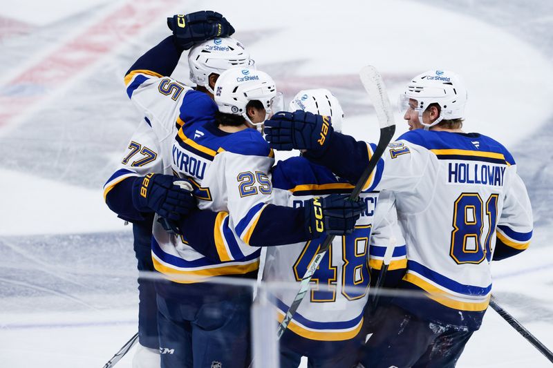 Dec 3, 2024; Winnipeg, Manitoba, CAN;  St. Louis Blues forward Jordan Kyrou (25) is congratulated by his team mates on his goal against the Winnipeg Jets during the third period at Canada Life Centre. Mandatory Credit: Terrence Lee-Imagn Images