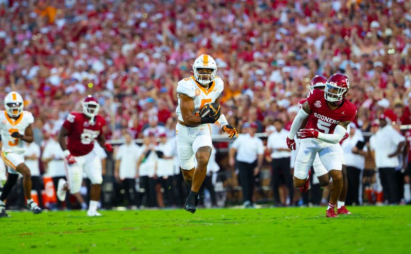 Sep 21, 2024; Norman, Oklahoma, USA;  Tennessee Volunteers wide receiver Bru McCoy (5) runs with the ball past Oklahoma Sooners defensive back Woodi Washington (5) during the first quarterat Gaylord Family-Oklahoma Memorial Stadium. Mandatory Credit: Kevin Jairaj-Imagn Images