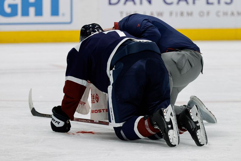 Apr 9, 2024; Denver, Colorado, USA; Colorado Avalanche defenseman Devon Toews (7) is tended to after taking a stick to the face in the first period against the Minnesota Wild at Ball Arena. Mandatory Credit: Isaiah J. Downing-USA TODAY Sports