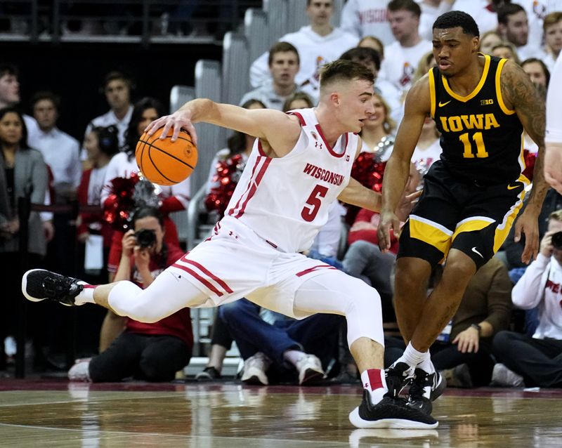 Feb 22, 2023; Madison, Wisconsin, USA; Wisconsin forward Tyler Wahl (5) controls the ball against Iowa guard Tony Perkins (11) during the first half at Kohl Center. Mandatory Credit: Mark Hoffman-USA TODAY Sports