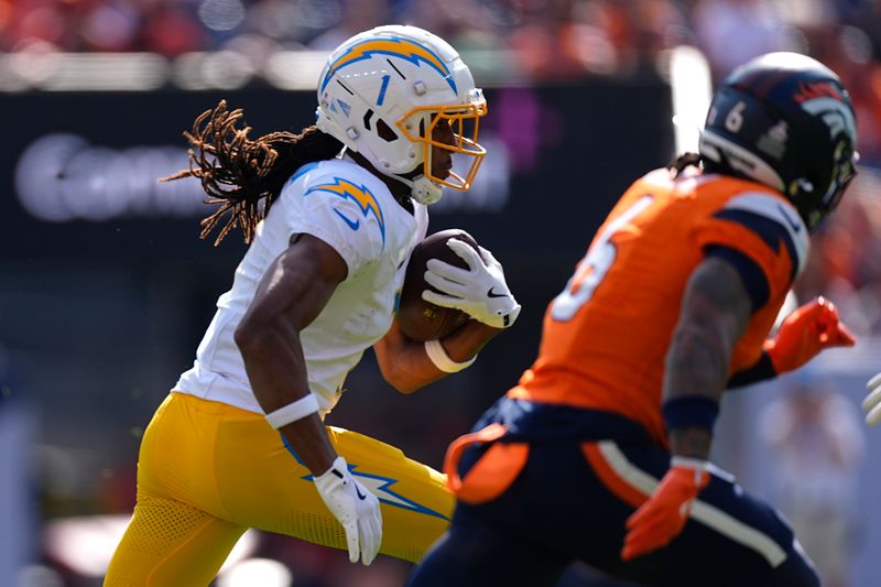 Los Angeles Chargers wide receiver Quentin Johnston (1) runs with the football as Denver Broncos safety P.J. Locke (6) follows during the first half of an NFL football game, Sunday, Oct. 13, 2024, in Denver. (AP Photo/David Zalubowski)