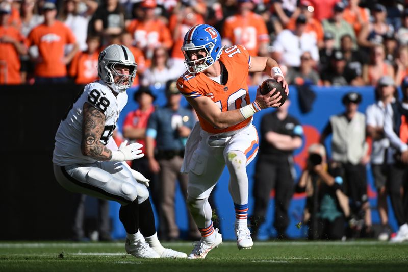 Denver Broncos quarterback Bo Nix (10) pulls away from Las Vegas Raiders defensive end Maxx Crosby (98) during the second half of an NFL football game, Sunday, Oct. 6, 2024, in Denver. (AP Photo/Geneva Heffernan)