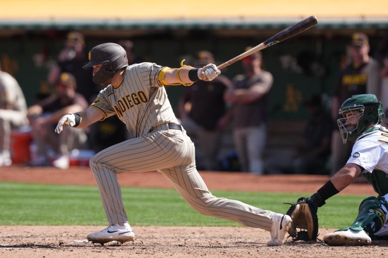 Sep 17, 2023; Oakland, California, USA; San Diego Padres second baseman Matthew Batten (17) hits an RBI single against the Oakland Athletics during the sixth inning at Oakland-Alameda County Coliseum. Mandatory Credit: Darren Yamashita-USA TODAY Sports