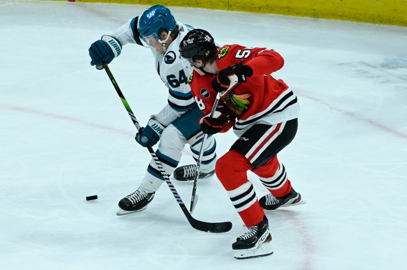 Jan 16, 2024; Chicago, Illinois, USA; San Jose Sharks right wing Mitchell Russell (64) and Chicago Blackhawks right wing MacKenzie Entwistle (58) chase the puck during the second period at United Center. Mandatory Credit: Matt Marton-USA TODAY Sports