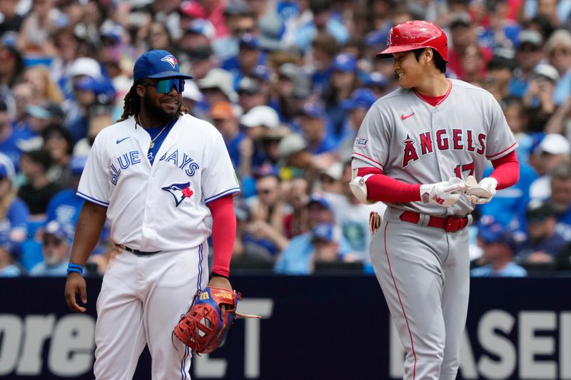 Jul 30, 2023; Toronto, Ontario, CAN; Los Angeles Angels designated hitter Shohei Ohtani (17) talks to Toronto Blue Jays first baseman Vladimir Guerrero Jr. (27) after his single during the third inning at Rogers Centre. Mandatory Credit: John E. Sokolowski-USA TODAY Sports