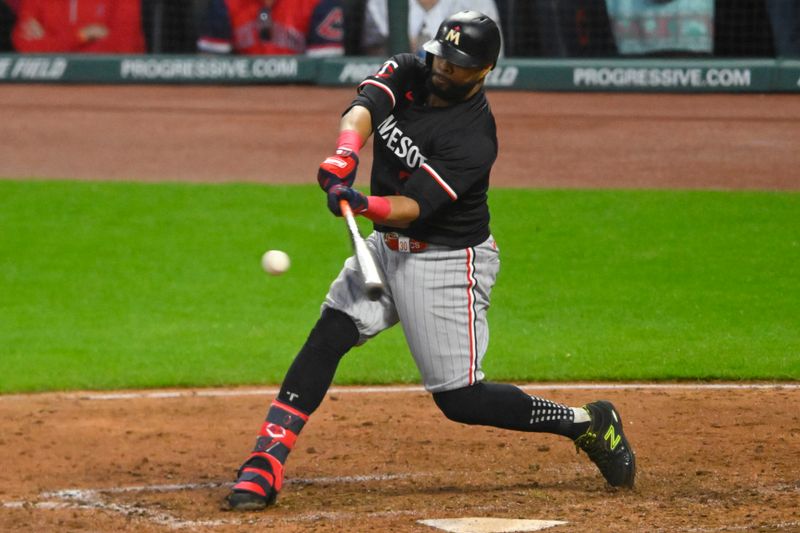 May 18, 2024; Cleveland, Ohio, USA; Minnesota Twins first baseman Carlos Santana (30) hits an RBI single in the ninth inning against the Cleveland Guardians at Progressive Field. Mandatory Credit: David Richard-USA TODAY Sports