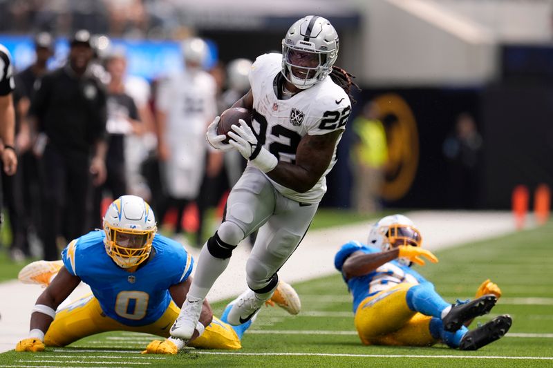 Las Vegas Raiders running back Alexander Mattison (22) runs for a touchdown against Los Angeles Chargers linebacker Daiyan Henley (0) and cornerback Asante Samuel Jr. during the first half of an NFL football game, Sunday, Sept. 8, 2024, in Inglewood, Calif. (AP Photo/Marcio Jose Sanchez)