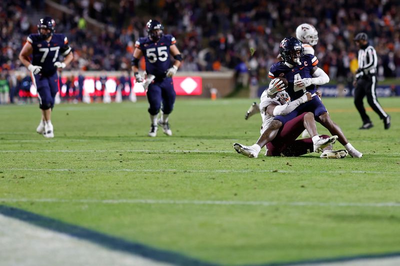 Nov 25, 2023; Charlottesville, Virginia, USA; Virginia Cavaliers wide receiver Malik Washington (4) catches a pass as Virginia Tech Hokies linebacker Alan Tisdale (34) defends during the third quarter at Scott Stadium. Mandatory Credit: Geoff Burke-USA TODAY Sports