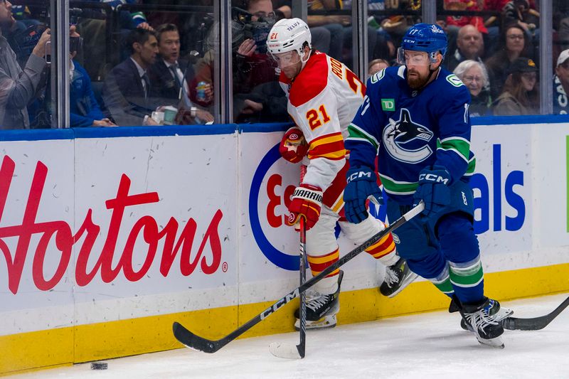 Oct 9, 2024; Vancouver, British Columbia, CAN; Vancouver Canucks defenseman Filip Hronek (17) checks Calgary Flames forward Kevin Rooney (21) during the first period at Rogers Arena. Mandatory Credit: Bob Frid-Imagn Images