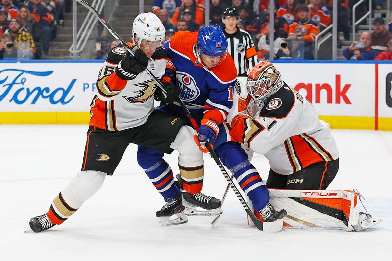 Nov 26, 2023; Edmonton, Alberta, CAN; Edmonton Oilers forward Mattias Janmark (13) tries to knock a loose puck past Anaheim Ducks goaltender Lucas Dostal (1) during the first period at Rogers Place. Mandatory Credit: Perry Nelson-USA TODAY Sports