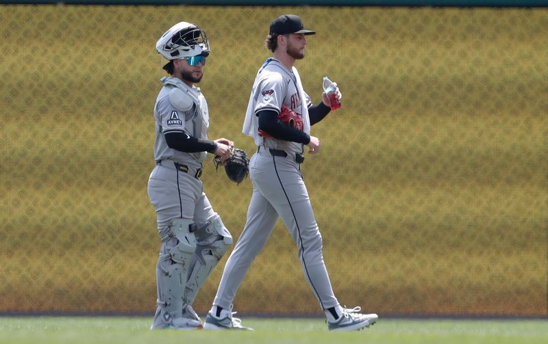 Aug 4, 2024; Pittsburgh, Pennsylvania, USA;  Arizona Diamondbacks catcher Jose Herrera (11) and starting pitcher Ryne Nelson (19) make their way in from the bullpen to play the Pittsburgh Pirates at PNC Park. Mandatory Credit: Charles LeClaire-USA TODAY Sports