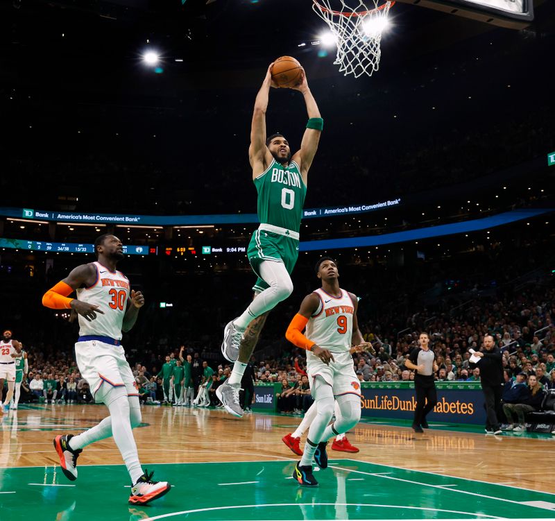 BOSTON, MA - DECEMBER 8: Jayson Tatum #0 of the Boston Celtics goes in for a dunk as Julius Randle #30 of the New York Knicks and RJ Barrett #9 look on during the second half at TD Garden on December 8, 2023 in Boston, Massachusetts. NOTE TO USER: User expressly acknowledges and agrees that, by downloading and/or using this Photograph, user is consenting to the terms and conditions of the Getty Images License Agreement. (Photo By Winslow Townson/Getty Images)