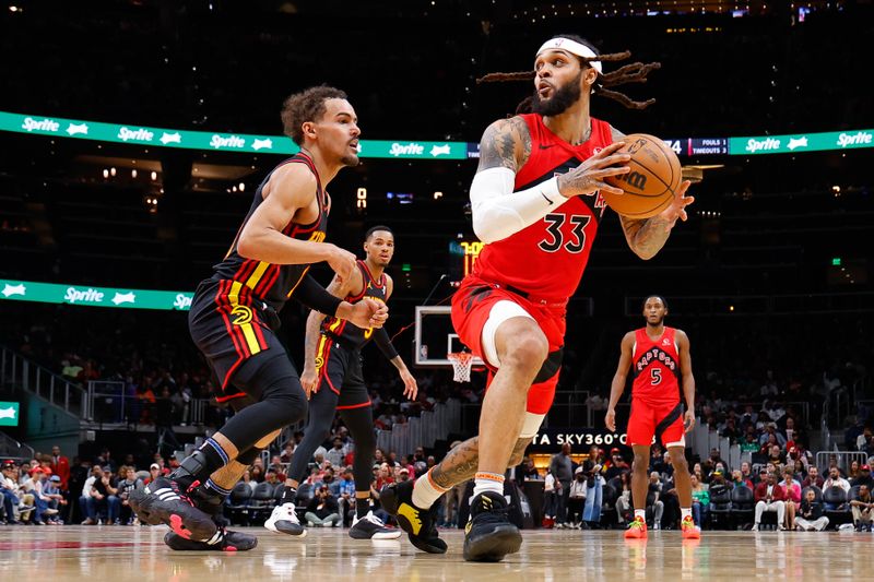 ATLANTA, GEORGIA - FEBRUARY 23: Gary Trent Jr. #33 of the Toronto Raptors drives against Trae Young #11 of the Atlanta Hawks during the third quarter at State Farm Arena on February 23, 2024 in Atlanta, Georgia. NOTE TO USER: User expressly acknowledges and agrees that, by downloading and or using this photograph, User is consenting to the terms and conditions of the Getty Images License Agreement. (Photo by Todd Kirkland/Getty Images)