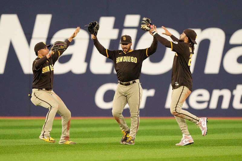 Jul 19, 2023; Toronto, Ontario, CAN; San Diego Padres left fielder Juan Soto (22) and center fielder Trent Grisham (1) and right fielder Fernando Tatis Jr. (23) celebrate a win over the Toronto Blue Jays at Rogers Centre. Mandatory Credit: John E. Sokolowski-USA TODAY Sports