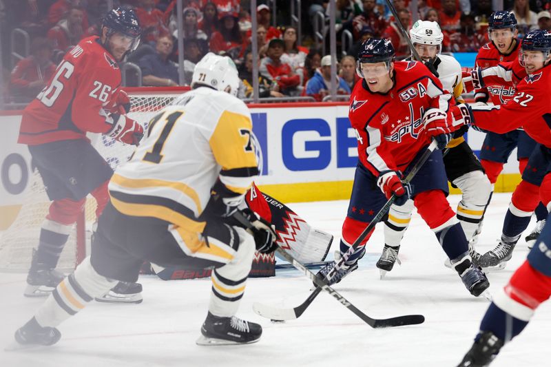 Nov 8, 2024; Washington, District of Columbia, USA; Washington Capitals defenseman John Carlson (74) clears the puck from Pittsburgh Penguins center Evgeni Malkin (71) in front of Capitals goaltender Charlie Lindgren (79) in the second period at Capital One Arena. Mandatory Credit: Geoff Burke-Imagn Images