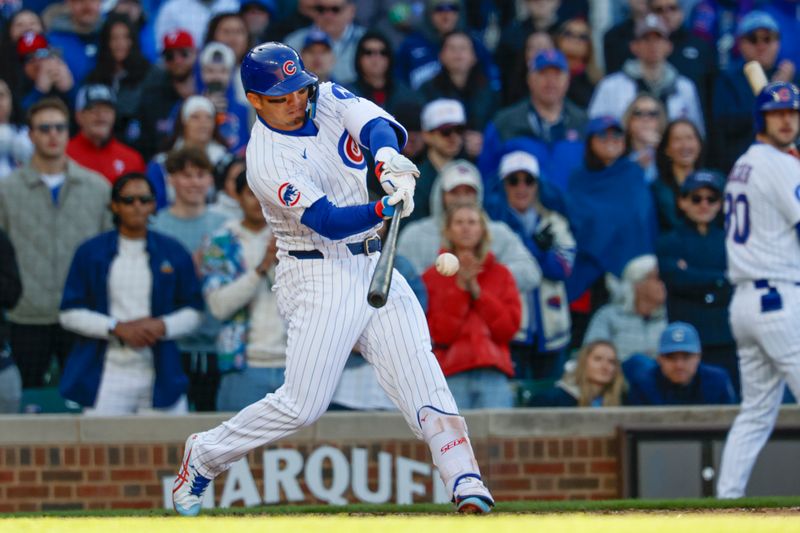 Apr 26, 2025; Chicago, Illinois, USA; Chicago Cubs designated hitter Seiya Suzuki (27) hits an RBI-single against the Philadelphia Phillies during the seventh inning at Wrigley Field. Mandatory Credit: Kamil Krzaczynski-Imagn Images