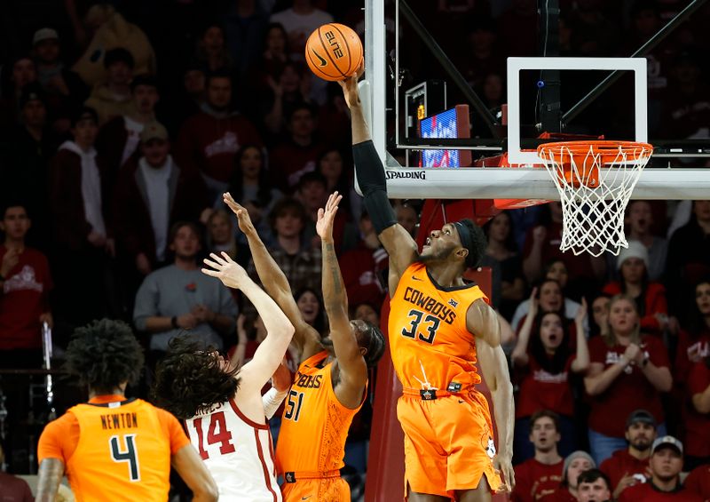 Feb 1, 2023; Norman, Oklahoma, USA; Oklahoma State Cowboys forward Moussa Cisse (33) blocks a shot by Oklahoma Sooners guard Bijan Cortes (14) during the first half at Lloyd Noble Center. Mandatory Credit: Alonzo Adams-USA TODAY Sports