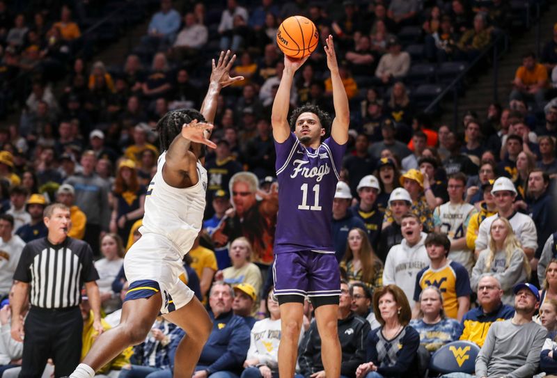 Mar 6, 2024; Morgantown, West Virginia, USA; TCU Horned Frogs guard Trevian Tennyson (11) shoots a three pointer over West Virginia Mountaineers guard Kobe Johnson (2) during the first half at WVU Coliseum. Mandatory Credit: Ben Queen-USA TODAY Sports