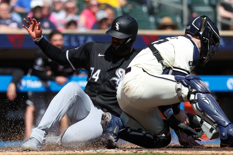 Apr 25, 2024; Minneapolis, Minnesota, USA; Chicago White Sox designated hitter Eloy Jiménez (74) scores on a sacrifice fly hit by center fielder Kevin Pillar (12) as Minnesota Twins catcher Ryan Jeffers (27) attempts a tag during the second inning at Target Field. Mandatory Credit: Matt Krohn-USA TODAY Sports