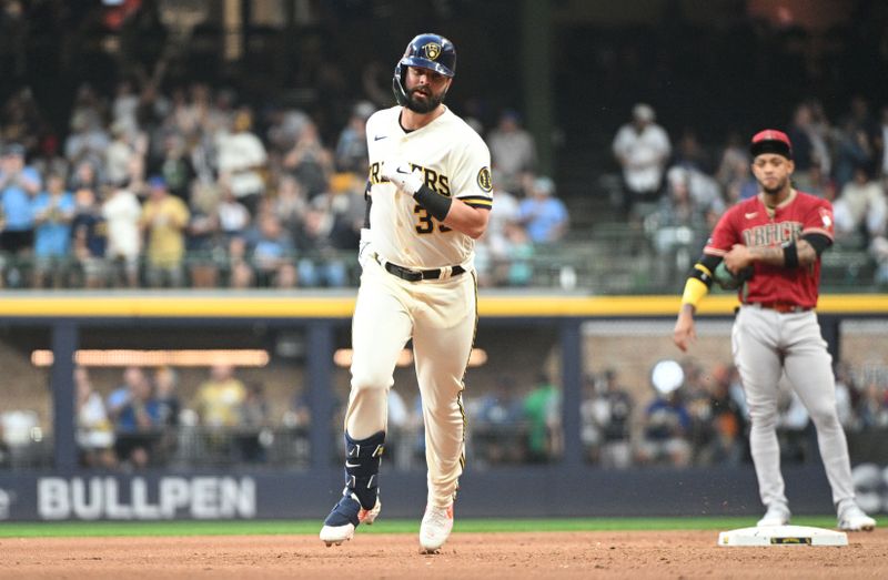 Jun 20, 2023; Milwaukee, Wisconsin, USA;  Milwaukee Brewers designated hitter Jesse Winker (33) rounds the bases after hitting a home run as Arizona Diamondbacks shortstop Geraldo Perdomo (2) looks on in the fourth inning at American Family Field. Mandatory Credit: Michael McLoone-USA TODAY Sports