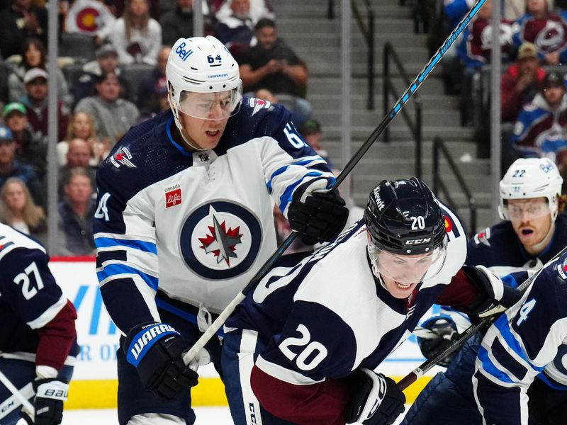 Dec 7, 2023; Denver, Colorado, USA; Colorado Avalanche center Ross Colton (20) and Winnipeg Jets defenseman Logan Stanley (64) during the second period at Ball Arena. Mandatory Credit: Ron Chenoy-USA TODAY Sports