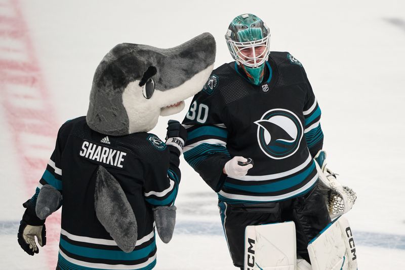 Mar 9, 2024; San Jose, California, USA; San Jose Sharks goaltender Magnus Chrona (30) celebrates with San Jose Sharks mascot Sharkie after defeating the against the Ottawa Senators during the third period at SAP Center at San Jose. Mandatory Credit: Robert Edwards-USA TODAY Sports