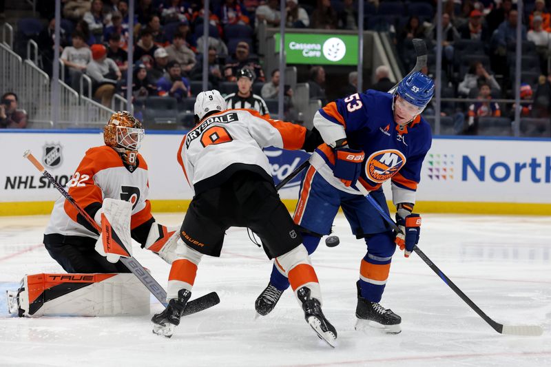 Jan 24, 2025; Elmont, New York, USA; New York Islanders center Casey Cizikas (53) fights for the puck against Philadelphia Flyers defenseman Jamie Drysdale (9) in front of Flyers goaltender Ivan Fedotov (82) during the second period at UBS Arena. Mandatory Credit: Brad Penner-Imagn Images