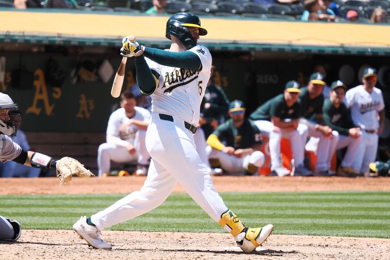 May 23, 2024; Oakland, California, USA; Oakland Athletics right fielder Seth Brown (15) hits a single against the Colorado Rockies during the eighth inning at Oakland-Alameda County Coliseum. Mandatory Credit: Kelley L Cox-USA TODAY Sports