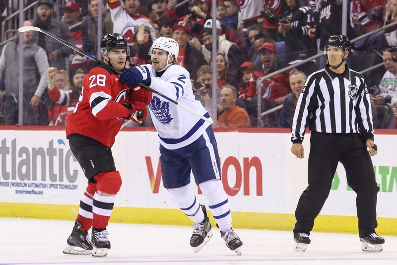 Oct 10, 2024; Newark, New Jersey, USA; Toronto Maple Leafs defenseman Simon Benoit (2) hits New Jersey Devils right wing Timo Meier (28) during the third period at Prudential Center. Mandatory Credit: Ed Mulholland-Imagn Images