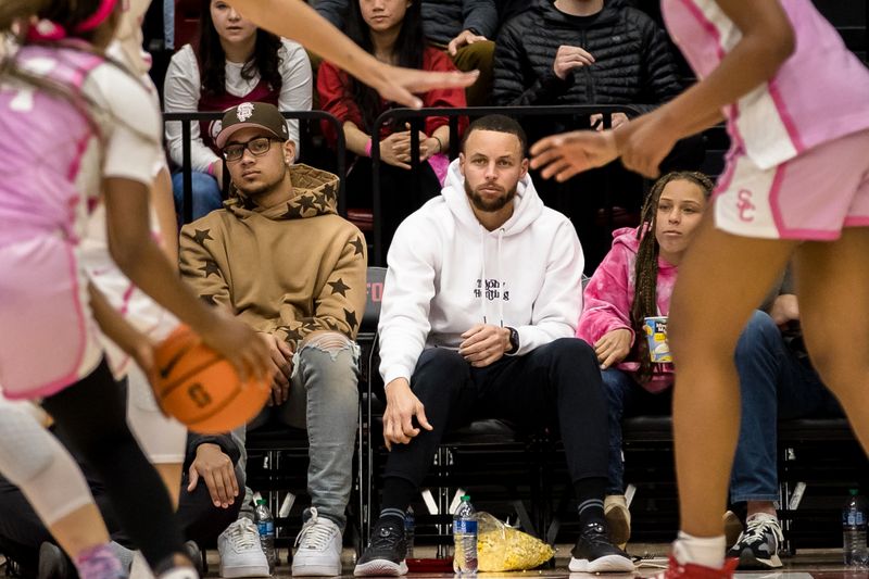 Feb 17, 2023; Stanford, California, USA;  Golden State Warriors guard watches the game between the Stanford Cardinal and the USC Trojans during the second half at Maples Pavilion. Mandatory Credit: John Hefti-USA TODAY Sports