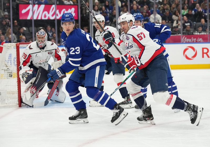 Dec 6, 2024; Toronto, Ontario, CAN; Toronto Maple Leafs left wing Matthew Knies (23) battles in front of the net with Washington Capitals defenseman Trevor van Riemsdyk (57) during the first period at Scotiabank Arena. Mandatory Credit: Nick Turchiaro-Imagn Images