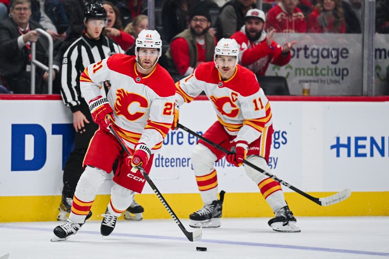 Nov 27, 2024; Detroit, Michigan, USA; Calgary Flames center Kevin Rooney (21) brings the puck up ice against the Detroit Red Wings during the second period at Little Caesars Arena. Mandatory Credit: Tim Fuller-Imagn Images