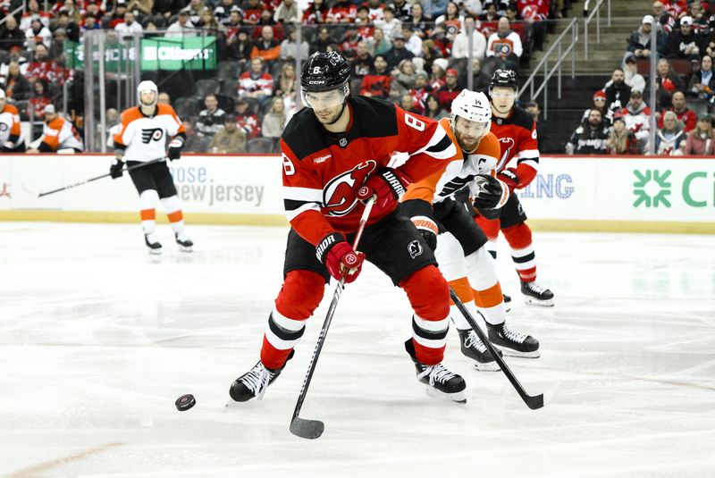 Jan 29, 2025; Newark, New Jersey, USA; New Jersey Devils defenseman Johnathan Kovacevic (8) controls the puck as Philadelphia Flyers center Sean Couturier (14) defends during the second period at Prudential Center. Mandatory Credit: John Jones-Imagn Images