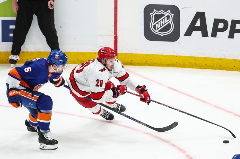 Apr 27, 2024; Elmont, New York, USA; New York Islanders defenseman Ryan Pulock (6) and Carolina Hurricanes center Sebastian Aho (20) chase the puck in the second overtime in game four of the first round of the 2024 Stanley Cup Playoffs at UBS Arena. Mandatory Credit: Wendell Cruz-USA TODAY Sports